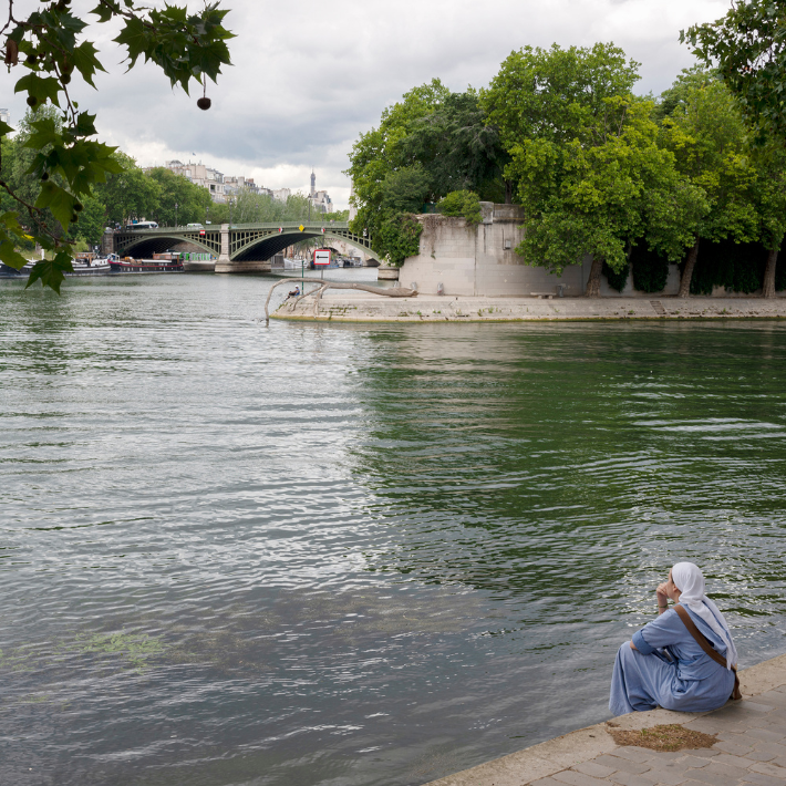 Vrouw zit aan de Seine in Parijs