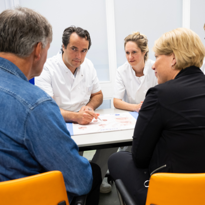 Patiënt en artsen in een spreekkamer Patiënt en artsen in een spreekkamer