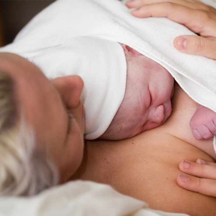 Moeder met baby op borst.